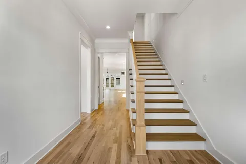 a view of a hallway with wooden floor and entryway
