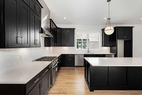 a kitchen with stainless steel appliances granite countertop a sink a stove and a refrigerator