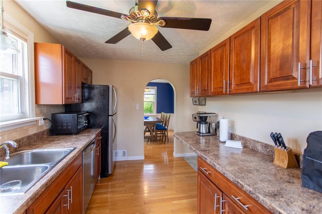 3211 Willett Road Pittsburgh, PA 15227 - Photo 9 of 27 a kitchen with stainless steel appliances granite countertop a sink dishwasher stove and refrigerator with wooden floor