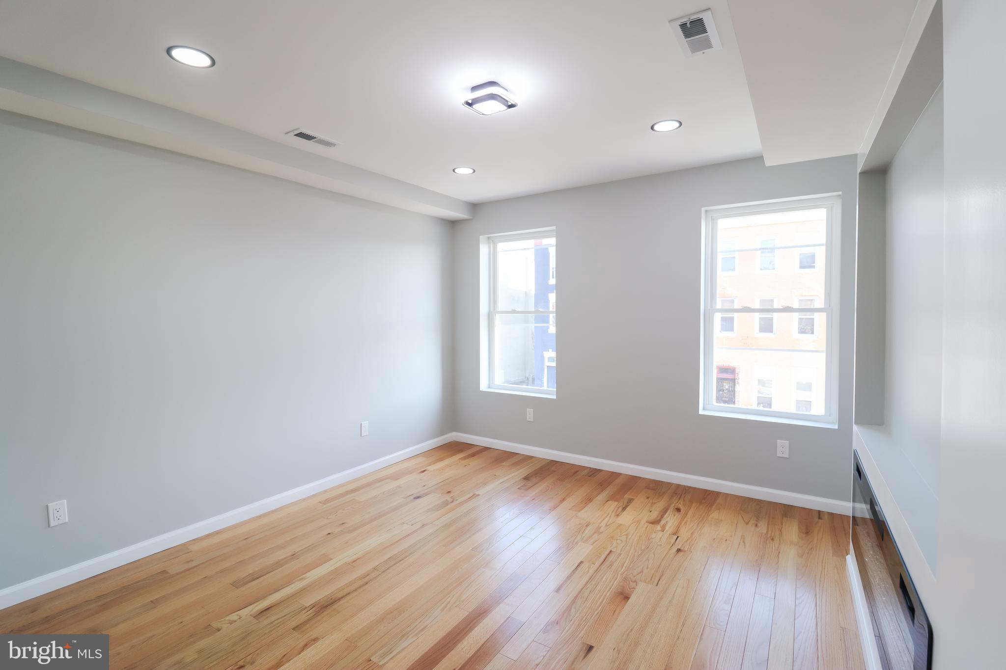 504 North Schroeder Street Baltimore, MD 21223 - Photo 11 of 31 an empty room with wooden floor and windows