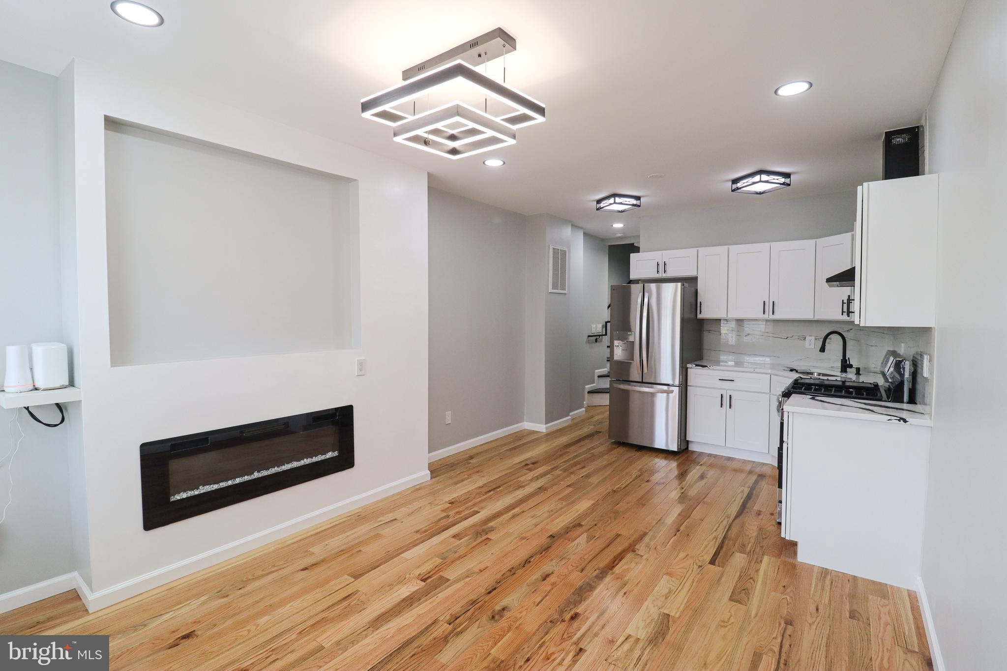 504 North Schroeder Street Baltimore, MD 21223 - Photo 2 of 31 a kitchen with stainless steel appliances a stove a microwave and white cabinets