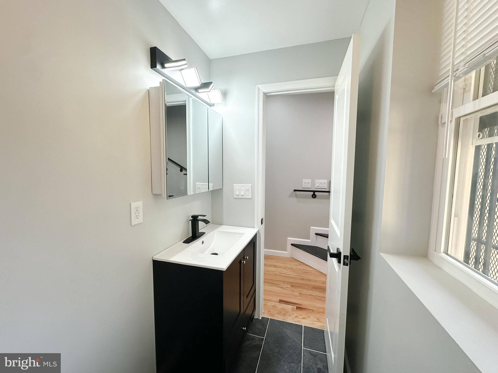 504 North Schroeder Street Baltimore, MD 21223 - Photo 6 of 31 a bathroom with a double vanity sink and mirror