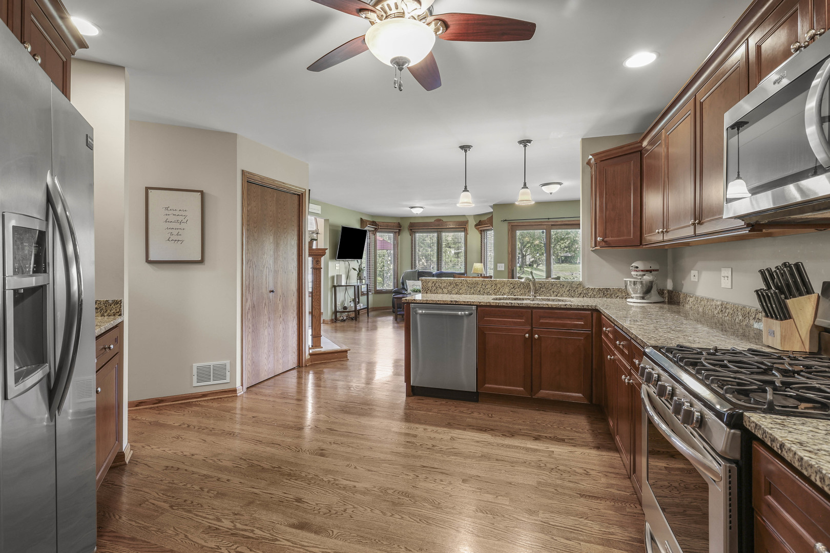 173 Harper Lane Lemont, IL 60439 - Photo 18 of 36 a kitchen with stainless steel appliances granite countertop a refrigerator a sink dishwasher a kitchen island with wooden cabinets and floor