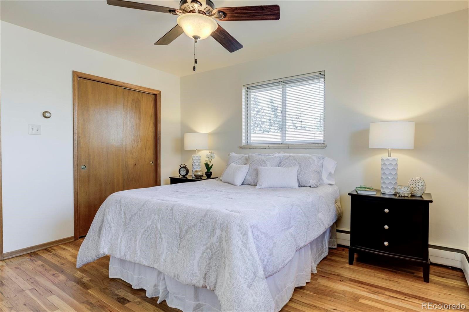 3170 Wright Street Wheat Ridge, CO 80215 - Photo 17 of 29 a bedroom with a bed and a chandelier