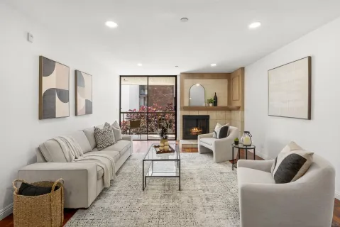 a living room with furniture fireplace and a large window