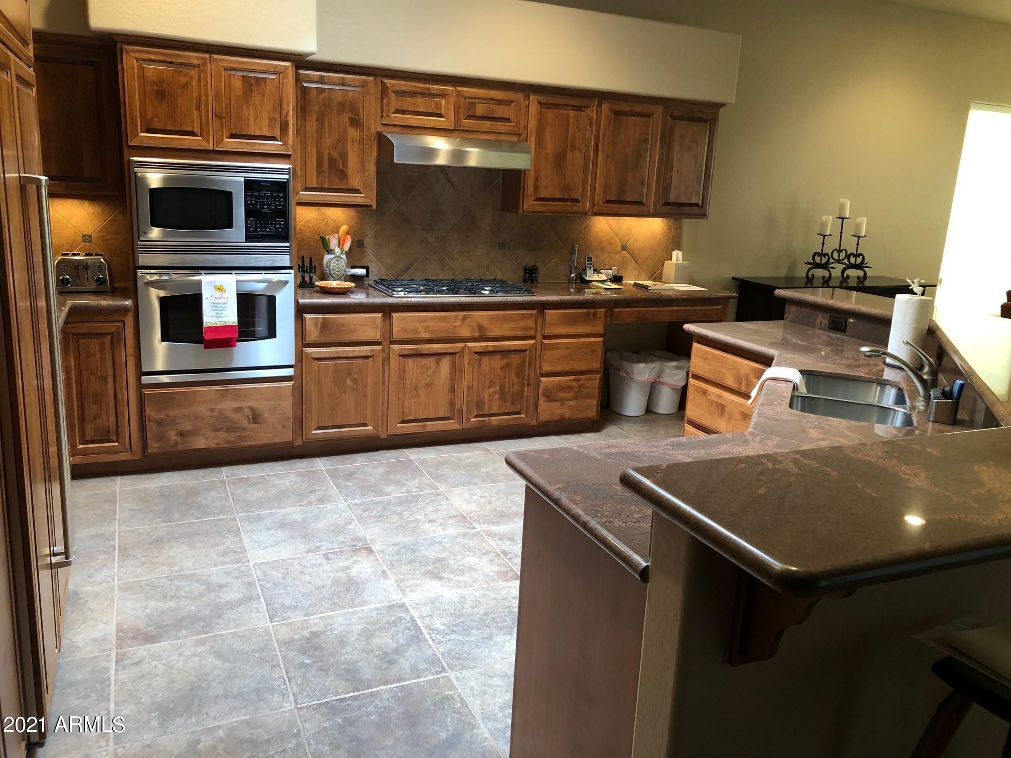 27707 North Quail Spring Road Rio Verde, AZ 85263 - Photo 4 of 14 a kitchen with stainless steel appliances a stove and a refrigerator
