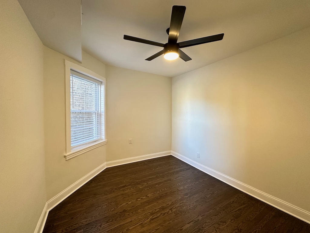 3045 West Addison Street, Unit 1 Chicago, IL 60618 - Photo 14 of 20 a view of a room with wooden floor a ceiling fan and windows