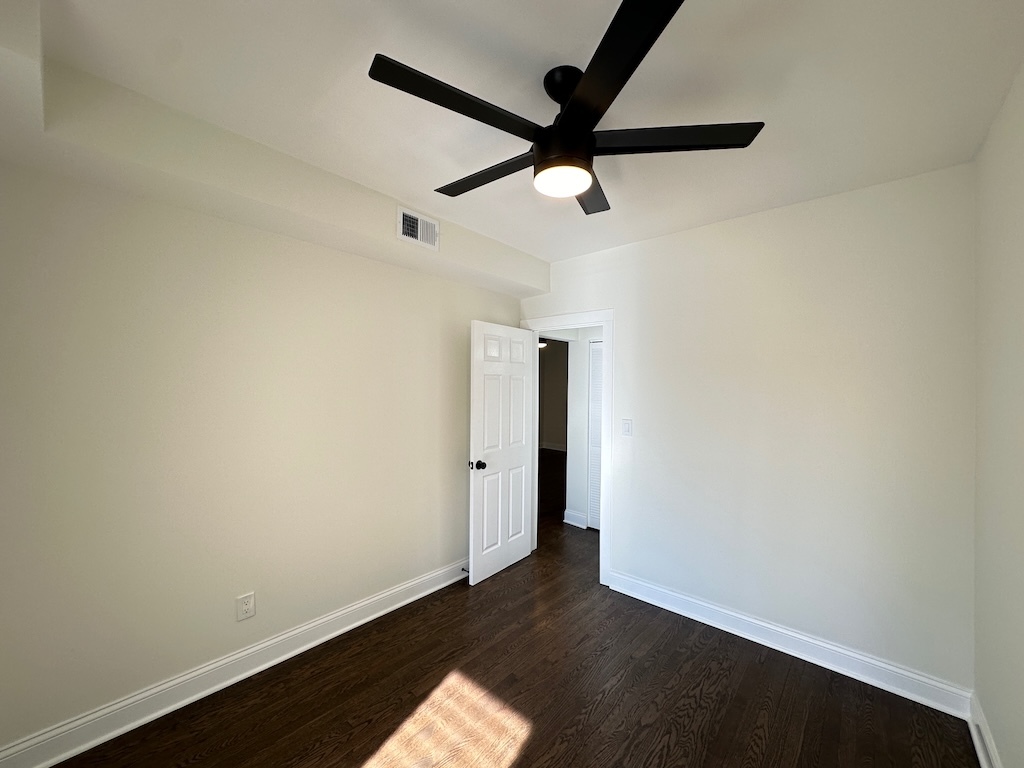 3045 West Addison Street, Unit 1 Chicago, IL 60618 - Photo 17 of 20 an empty room with wooden floor and a ceiling fan