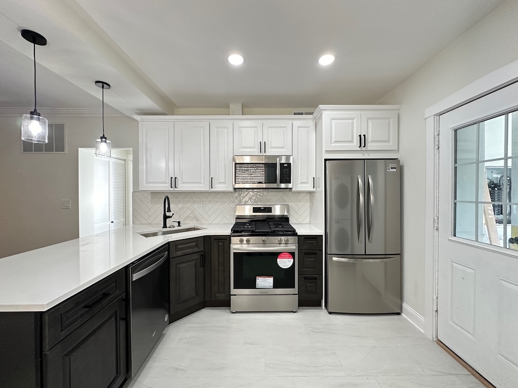 3045 West Addison Street, Unit 1 Chicago, IL 60618 - Photo 3 of 20 a kitchen with a sink a refrigerator and white cabinets