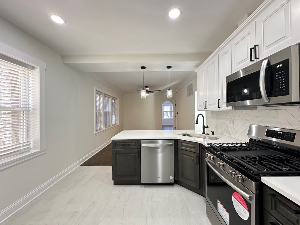 3045 West Addison Street, Unit 1 Chicago, IL 60618 - Photo 4 of 20 a kitchen with stainless steel appliances granite countertop a sink stove and microwave
