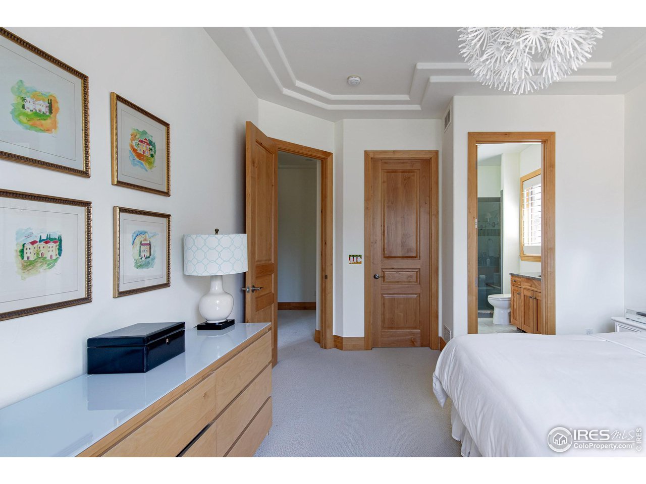 6922 Frying Pan Road Boulder, CO 80301 - Photo 23 of 39 a spacious bedroom with a bed and a lamp on dresser