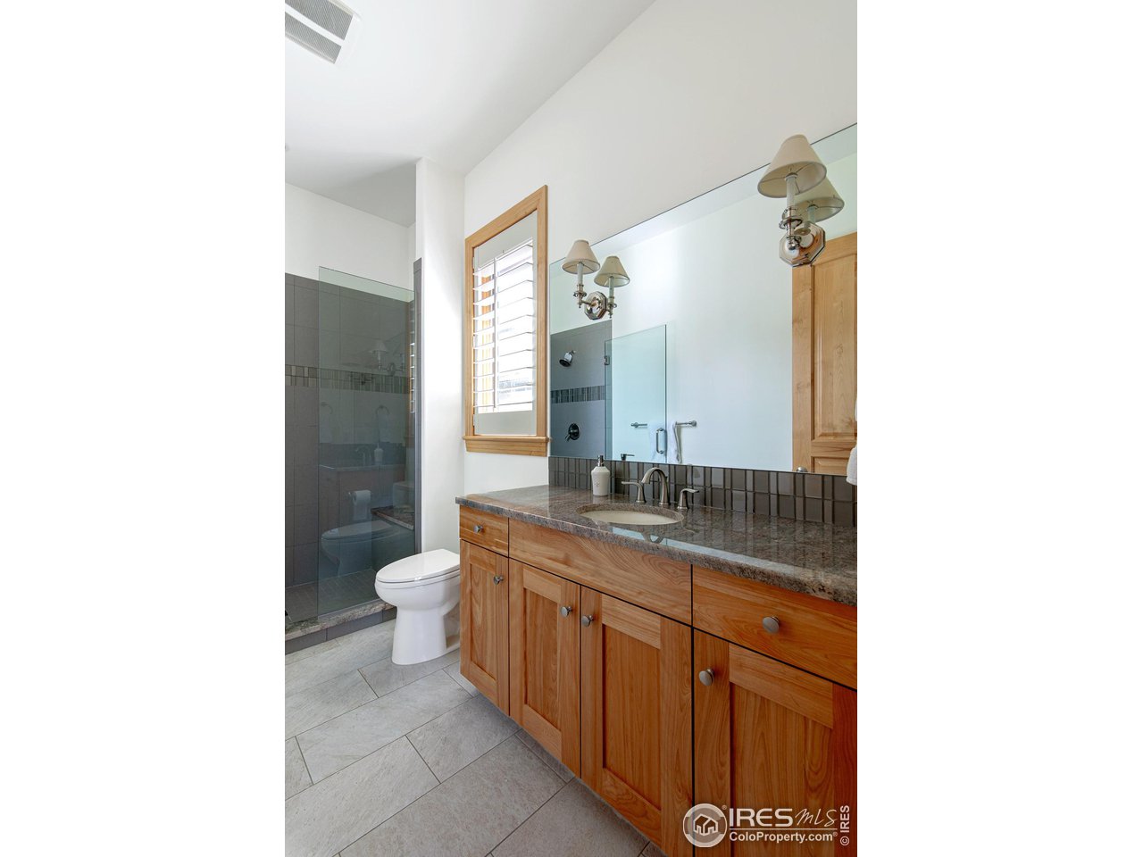 6922 Frying Pan Road Boulder, CO 80301 - Photo 24 of 39 a bathroom with a granite countertop sink a toilet and a mirror
