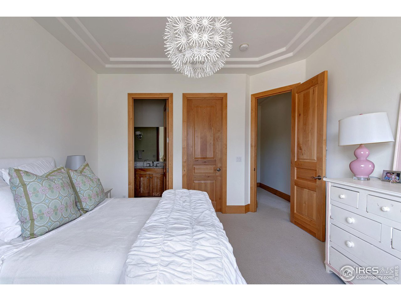 6922 Frying Pan Road Boulder, CO 80301 - Photo 27 of 39 a bedroom with a bed and a chandelier