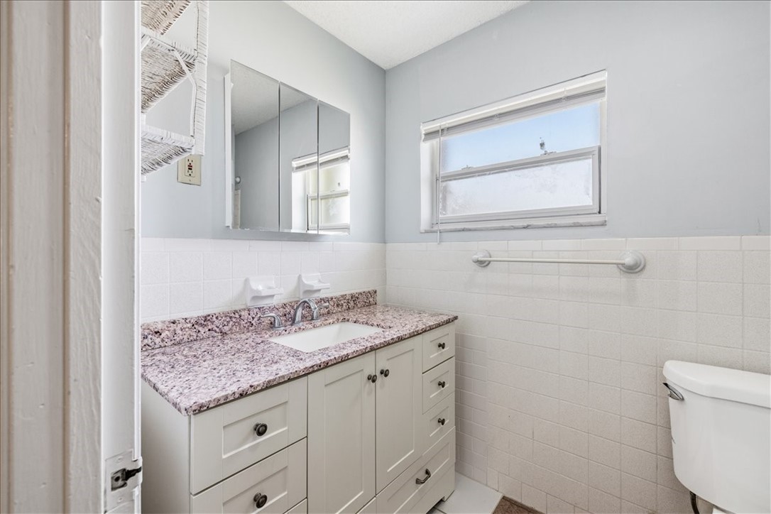 221 Balboa Street, Unit A Fort Pierce, FL 34949 - Photo 15 of 36 a bathroom with a granite countertop sink and a toilet