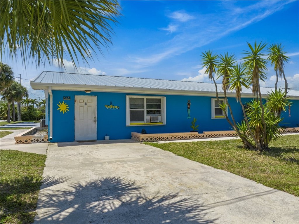221 Balboa Street, Unit A Fort Pierce, FL 34949 - Photo 28 of 36 a view of a house with a yard and palm trees