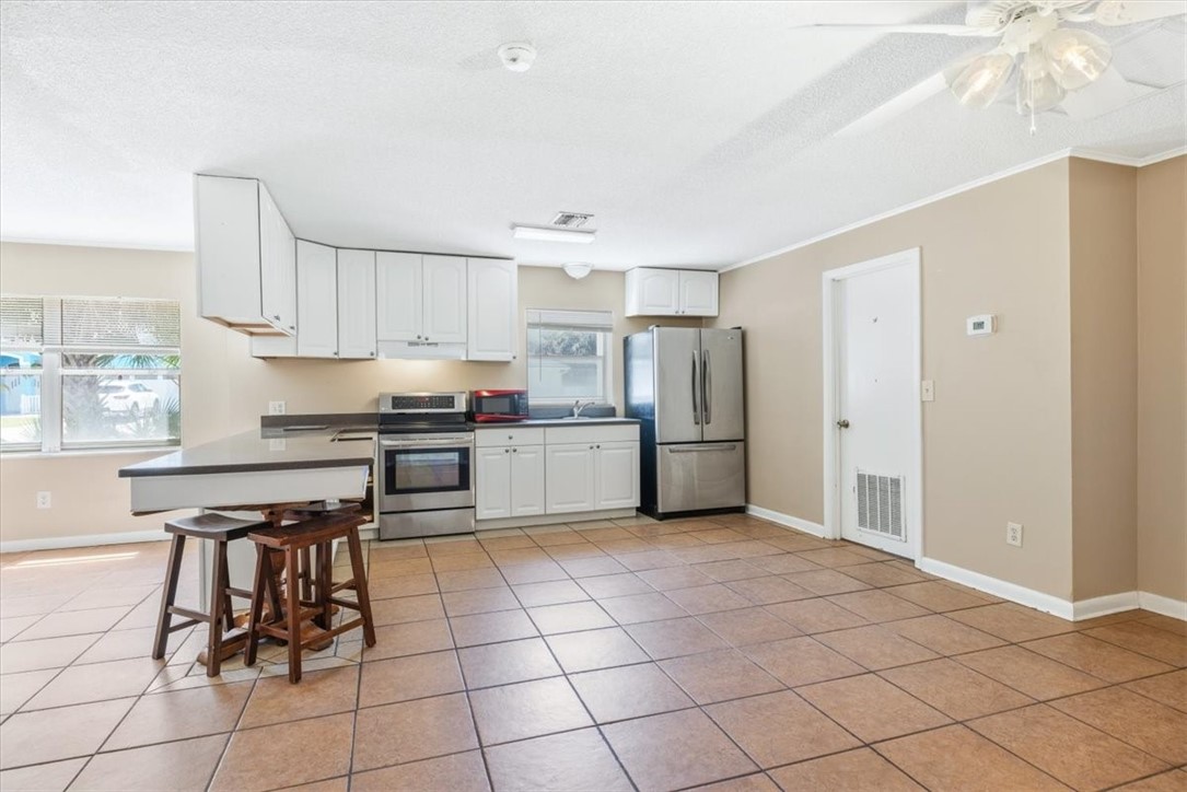 221 Balboa Street, Unit A Fort Pierce, FL 34949 - Photo 4 of 36 a kitchen with cabinets and chairs