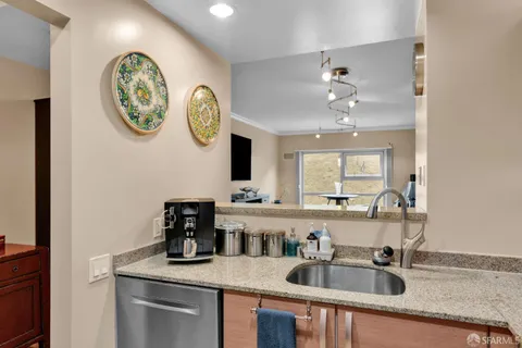 a kitchen with a sink dishwasher a clock and cabinets