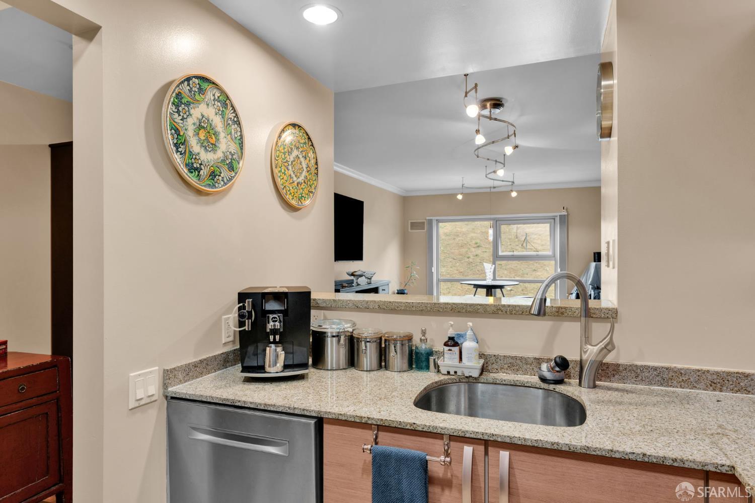 1 Mandalay Place, Unit 908 South San Francisco, CA 94080 - Photo 16 of 40 a kitchen with a sink dishwasher a clock and cabinets