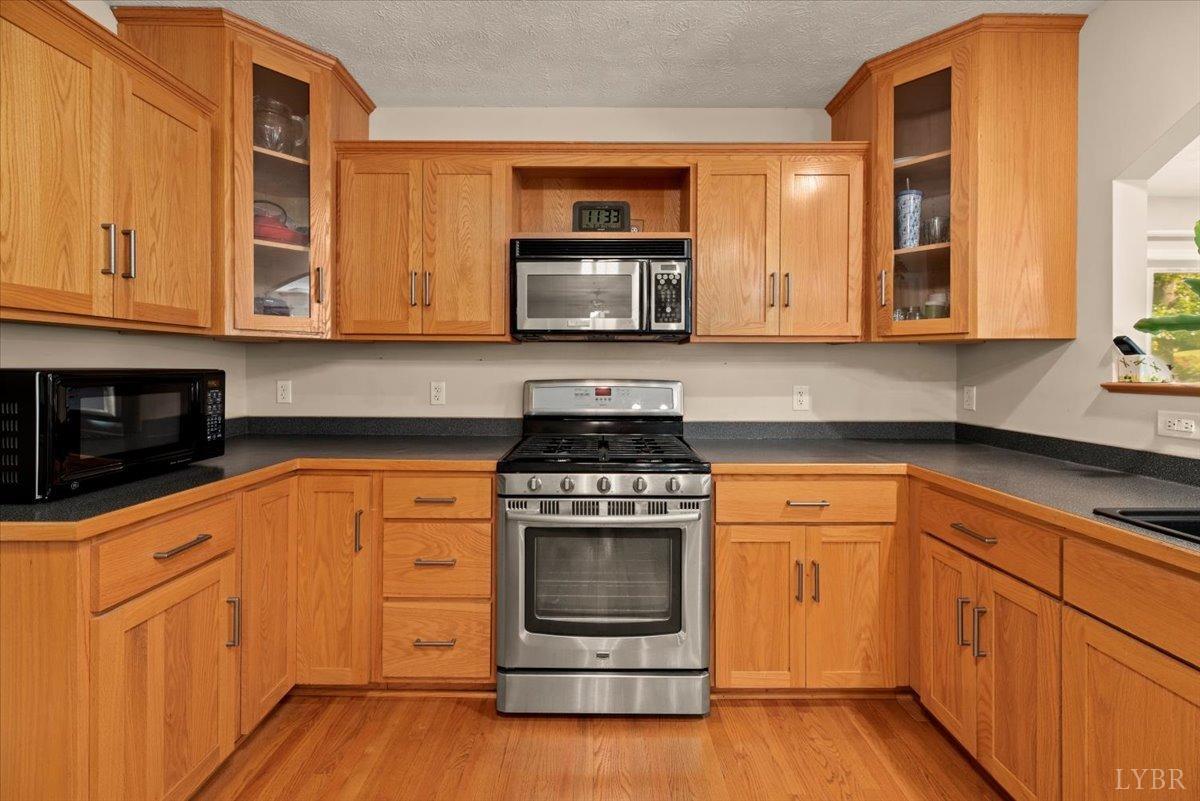 159 Blue Ridge Lane Amherst, VA 24521 - Photo 11 of 71 a kitchen with granite countertop a stove top oven a sink dishwasher and cabinets with wooden floor