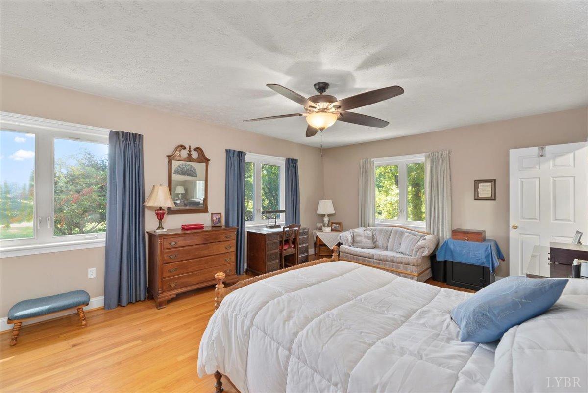 159 Blue Ridge Lane Amherst, VA 24521 - Photo 30 of 71 a bedroom with a large bed couch and windows