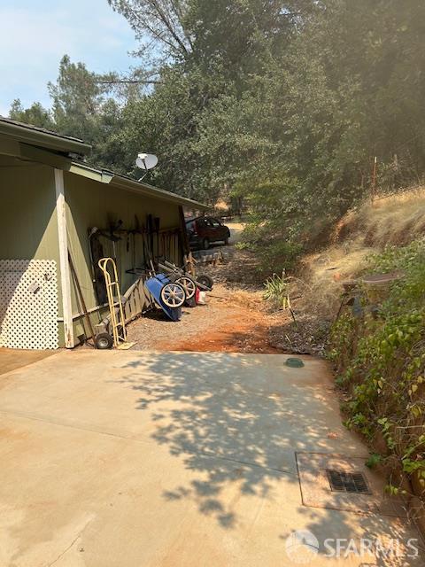 19481 Rambling Oak Drive Redding, CA 96003 - Photo 13 of 62 a view of a wooden house with a bench in the patio