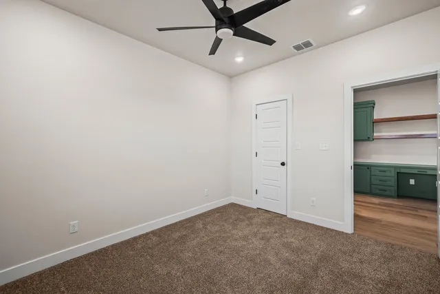 an empty room with a ceiling fan and a window