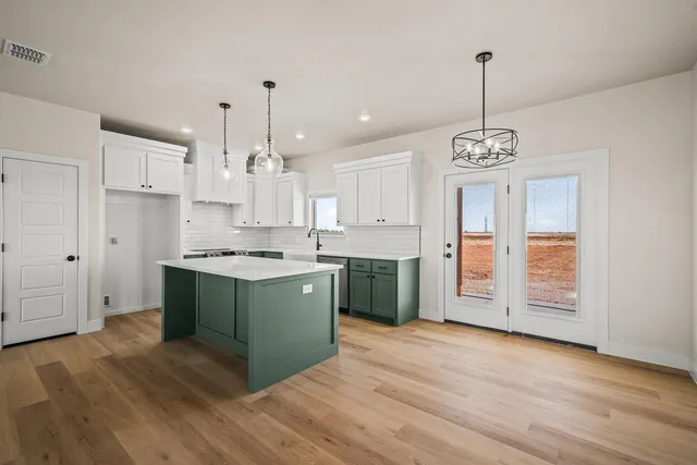 a kitchen with stainless steel appliances granite countertop a sink cabinets and a wooden floor