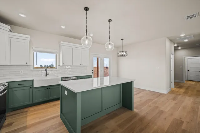 a kitchen with a sink a counter space and wooden floor