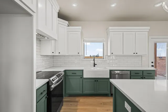 a kitchen with a sink dishwasher a stove and a refrigerator with wooden cabinets