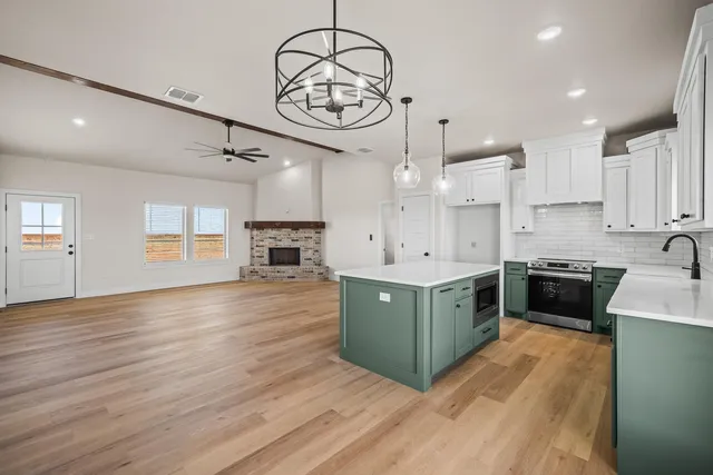 a view of empty room with wooden floor and fireplace