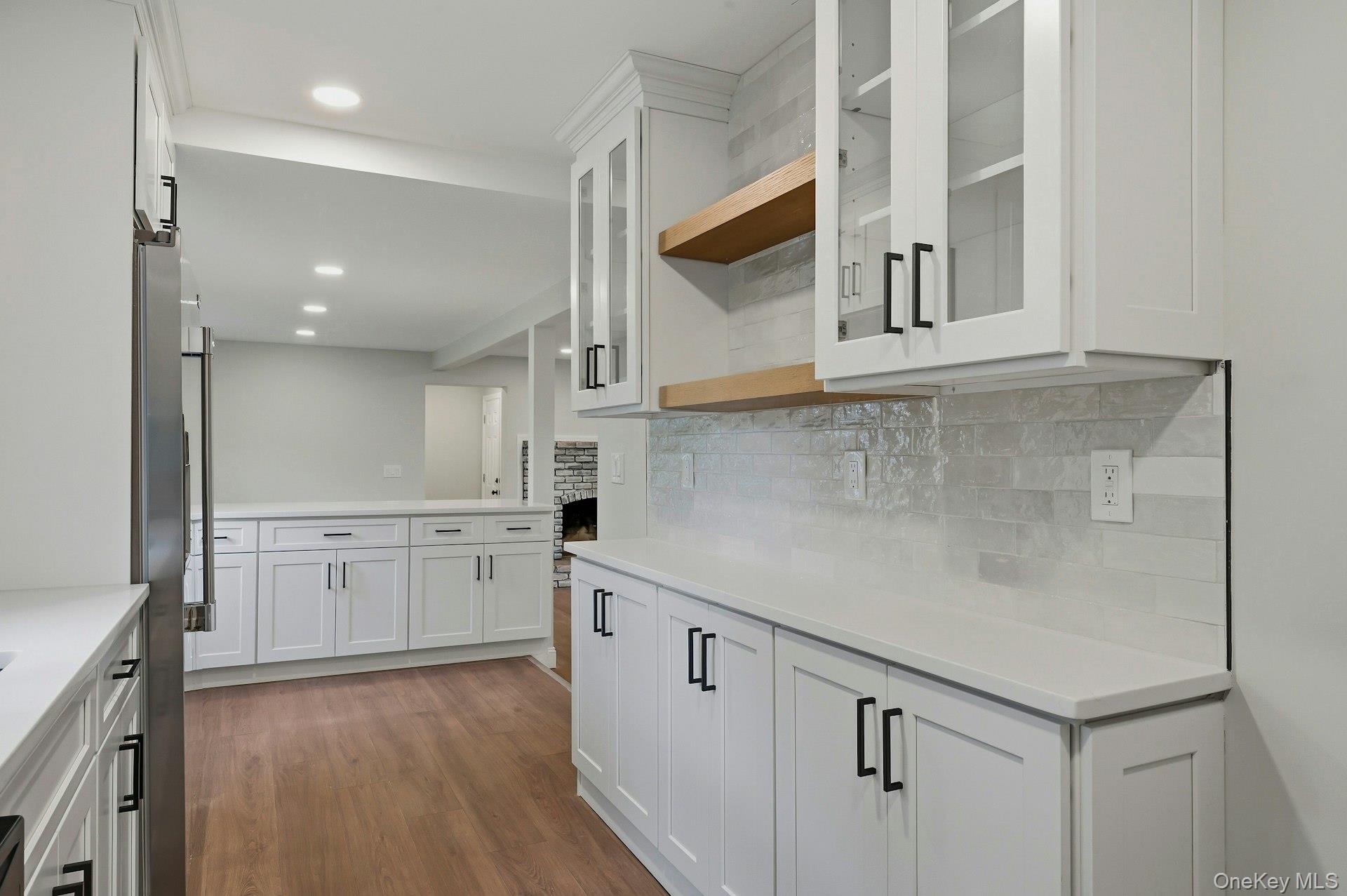 101 Rustic Road Centereach, NY 11720 - Photo 25 of 42 a kitchen with white cabinets and wooden floor
