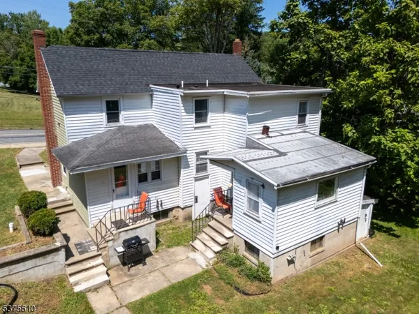 a view of a house with backyard and sitting area