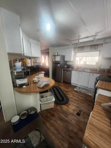 a kitchen with stainless steel appliances a stove a sink cabinets and wooden floor