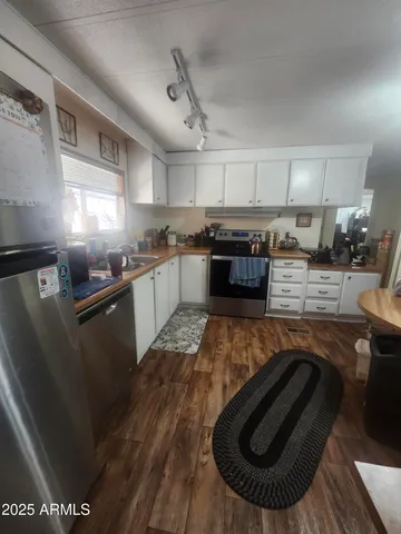 a kitchen with stainless steel appliances granite countertop a sink a stove top oven a counter space and cabinets