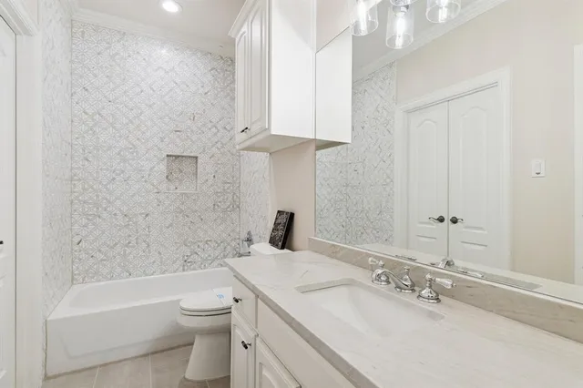 a bathroom with a granite countertop sink a toilet and bathtub