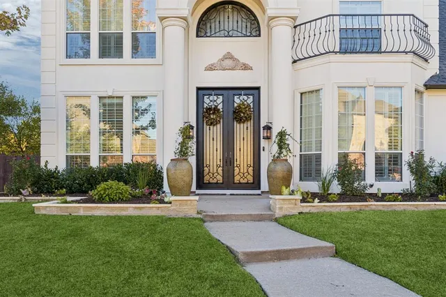 a front view of a building with a garden and plants