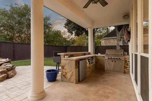 a view of a kitchen with a sink and dishwasher a barbeque with wooden floor