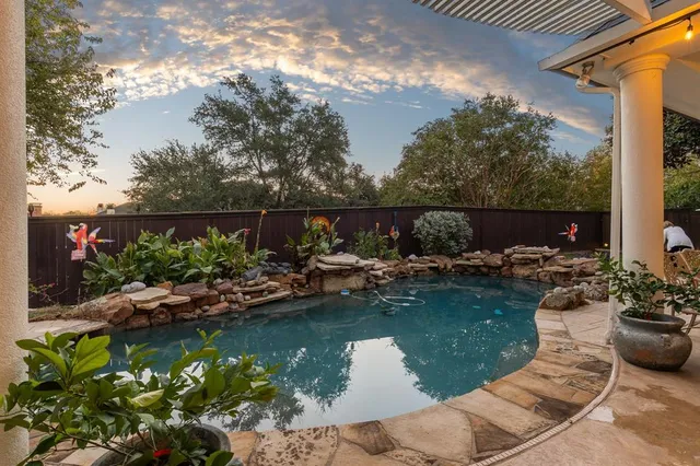 a view of a swimming pool with a patio and a garden