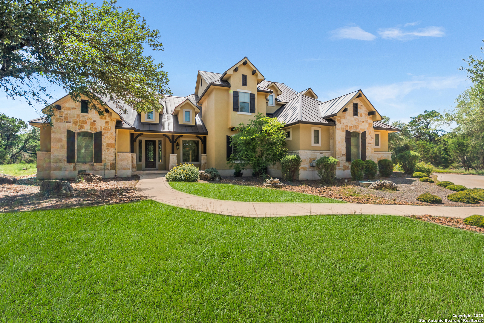 a front view of a house with a yard and potted plants
