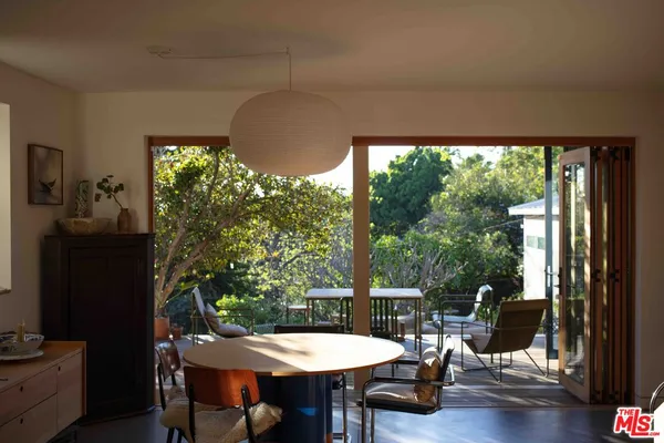 a living room with patio furniture and a floor to ceiling window