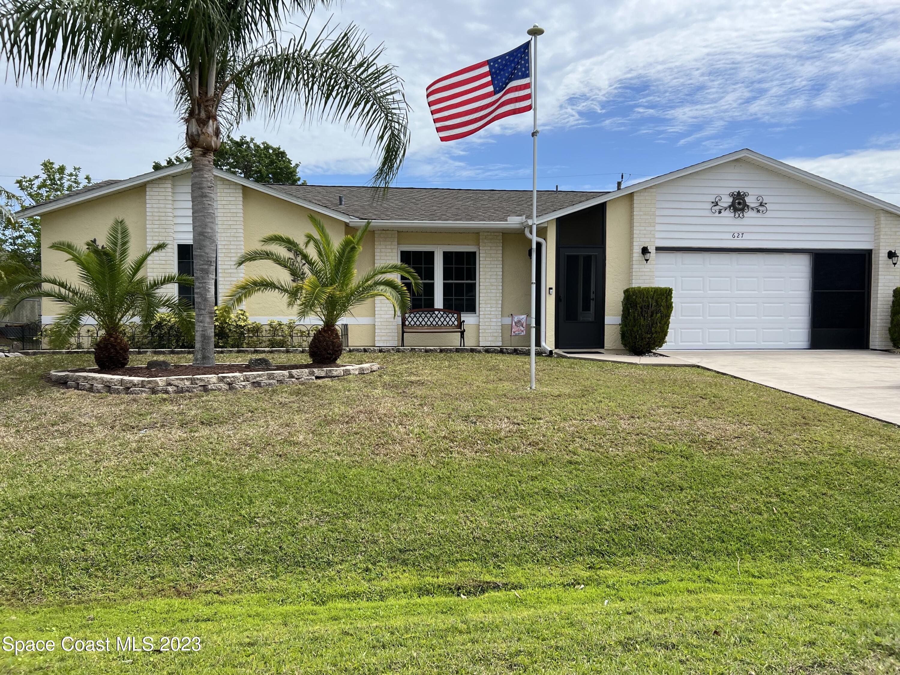 627 Rostock Circle Northwest Palm Bay, FL 32907 - Photo 1 of 1 a front view of a house with garden