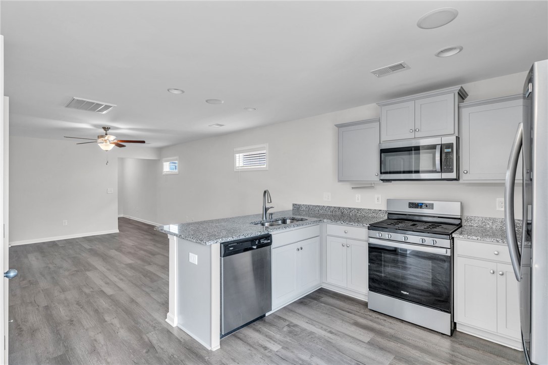 208 Samuel Street Pendleton, SC 29670 - Photo 9 of 32 Granite counters and stainless appliances define this open-concept kitchen.