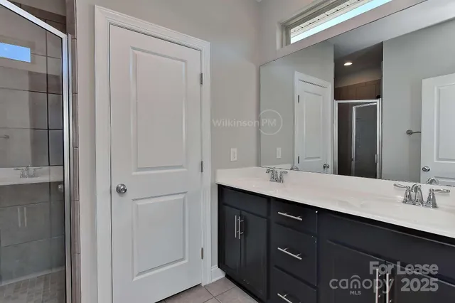 a bathroom with double vanity sink and a mirror