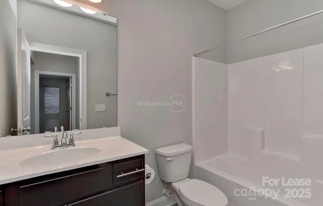 a bathroom with a sink toilet vanity and shower