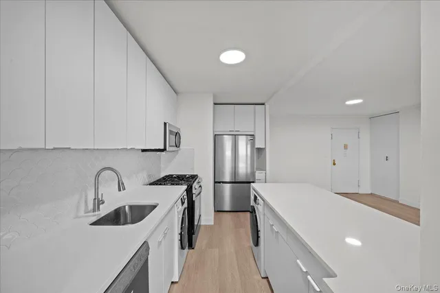 a kitchen with stainless steel appliances a sink stove and refrigerator