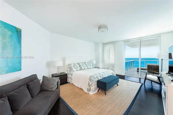 a bedroom with a bed couch and a large window