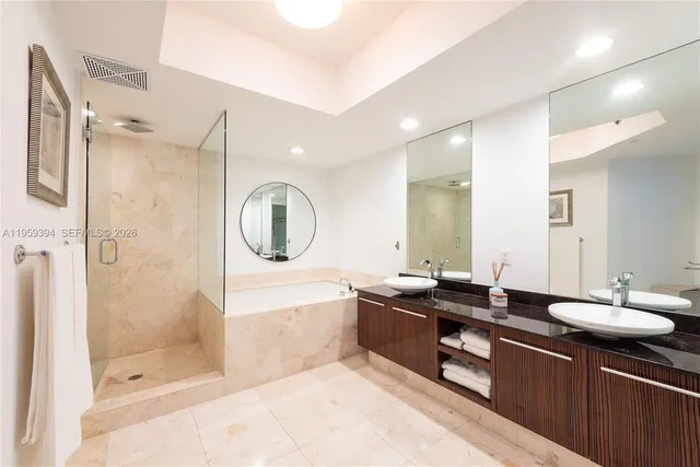 a bathroom with a bathtub shower sink mirror and toilet