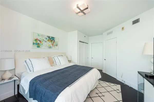a bedroom with a bed and a painting on the wall