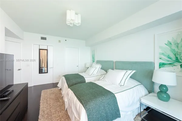 a bedroom with a bed lamp and a potted plant