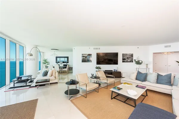 a living room with furniture flat screen tv and a large window